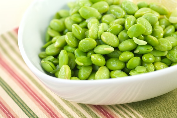 A bowl of soybeans or soya beans with a light drizzle of melted butter and lemon. This variety is called Edamame and is commonly served in Japanese restaurants and some Chinese restaurants. This legume is gaining popularity outside of East Asia as a healthful food staple.