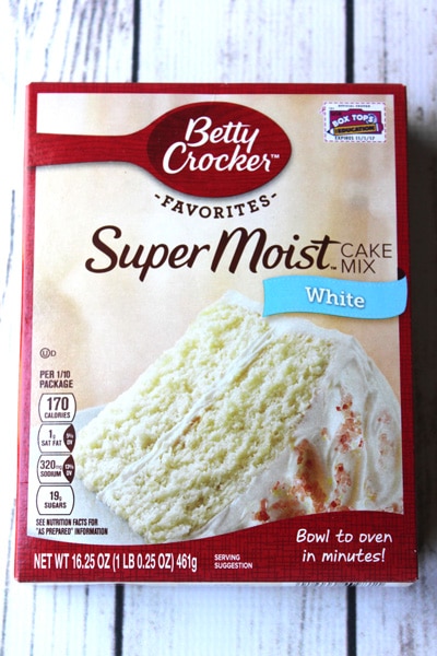 A box of Betty Crocker Super Moist white cake mix on a white plank wooden board.
