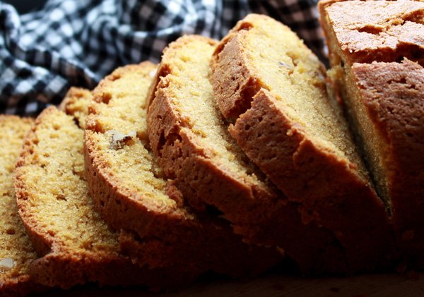 Close-up of thick slices of pumpkin bread with a black and white checkered napkin placed behind.