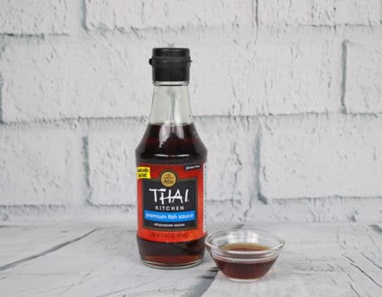 a jar of Thai fish sauce on a wooden board