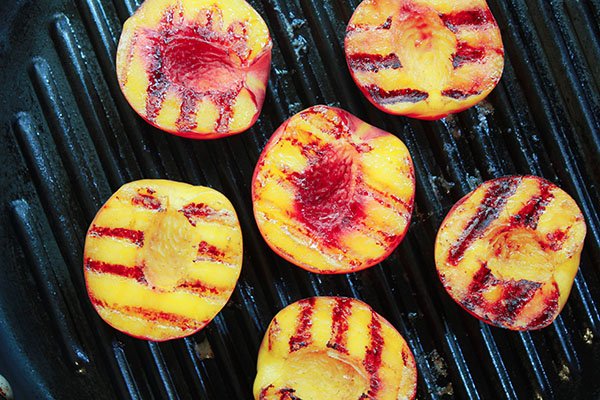 Grilled peaches grilling on a grill pan