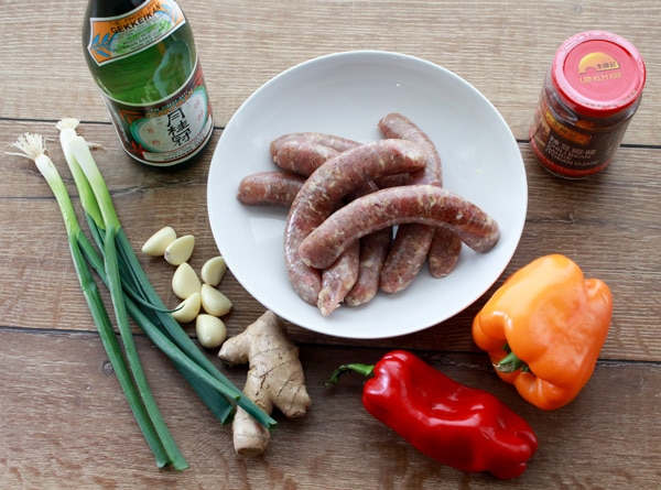 turkey sausage, orange and red bell peppers, garlic, ginger, scallions, sake, chili bean sauce on a wooden board.
