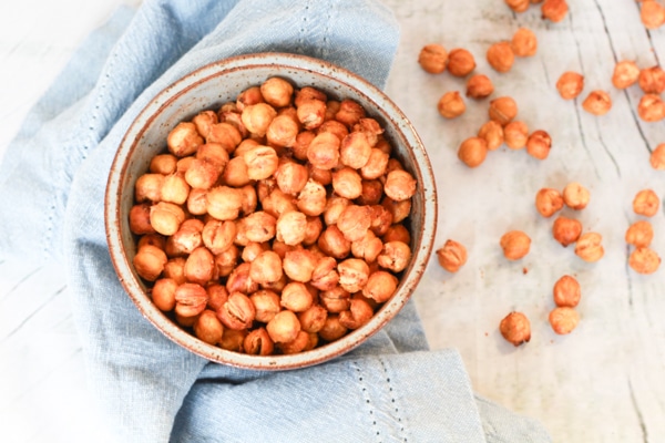 crispy spicy chickpeas in a bowl on top of a blue napkin.