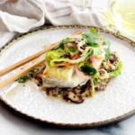 pan seared halibut on top of a bed of quinoa and topped with a spicy nuoc cham slaw