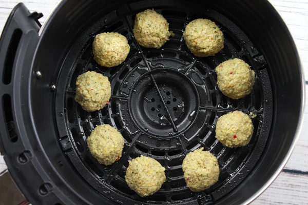 Falafel balls placed in an air fryer ready to be cooked