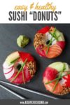 three sushi donuts on a gray board with silver chopsticks