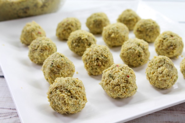Uncooked falafel balls on a white serving plate