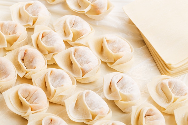 uncooked homemade Chinese dumplings with wrappers