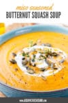 miso butternut squash soup in a blue bowl garnished with pumpkin seeds and herbs
