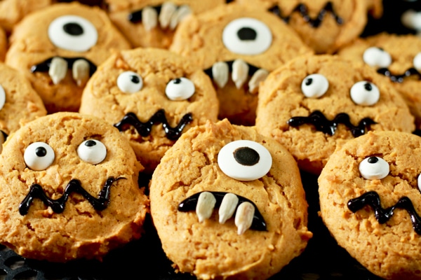decorated pumpkin monster cookies on a black background