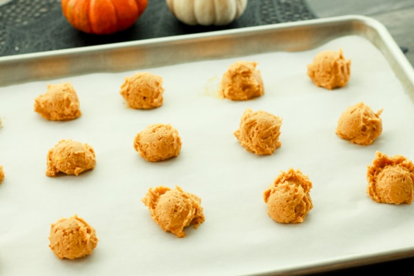 raw pumpkin batter scoops on a cookie sheet lined with parchment paper