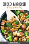 chicken and broccoli stir fry in a large wok with a wooden spatula