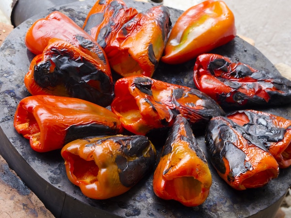 char-grilled mini peppers on a black board
