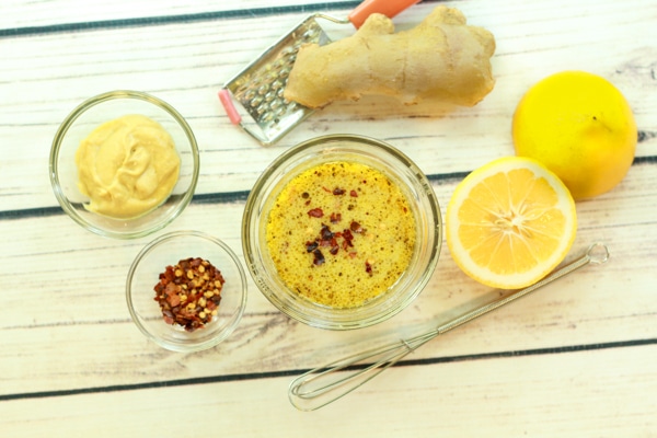 ingredients for tangy lemon vinaigrette, lemons, Dijon mustard, red pepper flakes, and fresh ginger