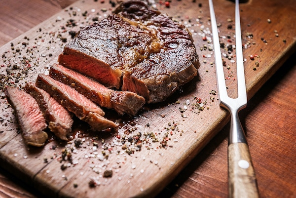 tasty and fresh, very juicy grilled steak sliced on a wooden board