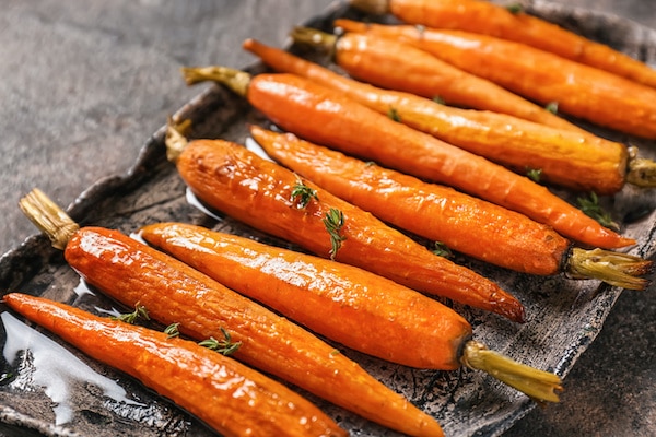 A plate of tasty roasted carrots on a table