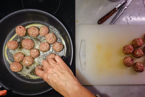 turkey meatballs being fried up in a skillet on the stove