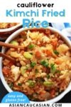 A bowl of Kimchi cauliflower fried rice with chopsticks and blue and white napkin on the side