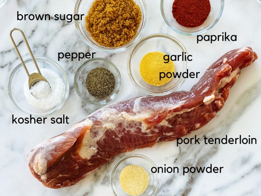 Ingredients for making the dry spice rub for pork tenderloin on a white marbled board.