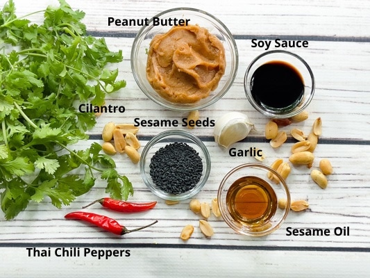 Ingredients for making spicy peanut dressing on top of a white board.