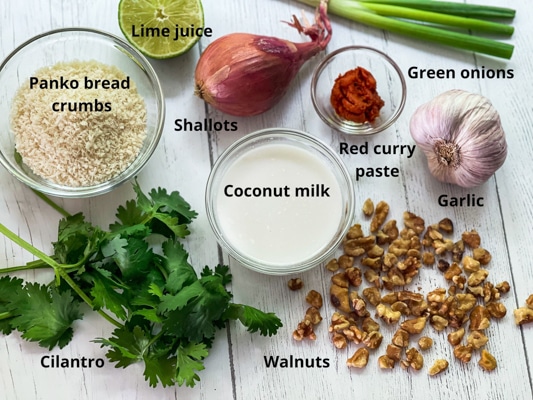 Ingredients on a white board for making walnut crusted halibut, including bread crumbs, coconut milk, walnuts, and red curry paste.
