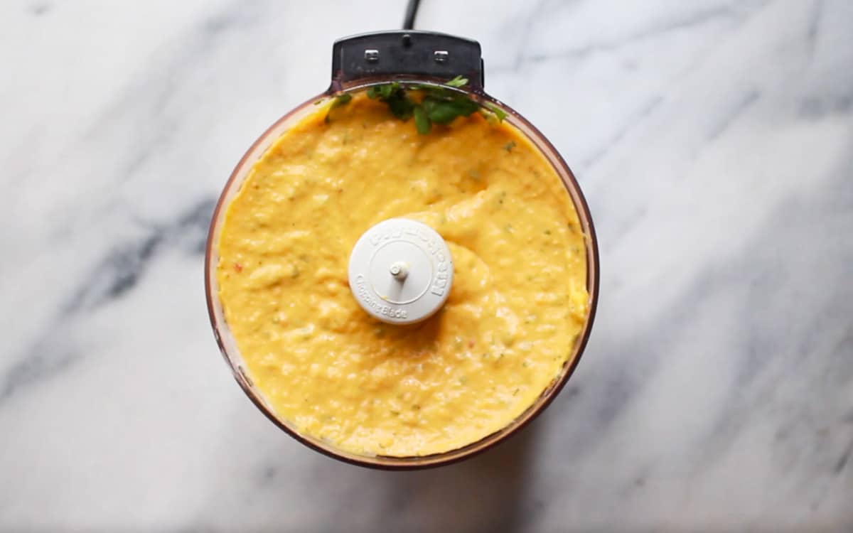 a mini food processor filled with roasted butternut squash dip on top of a marble surface
