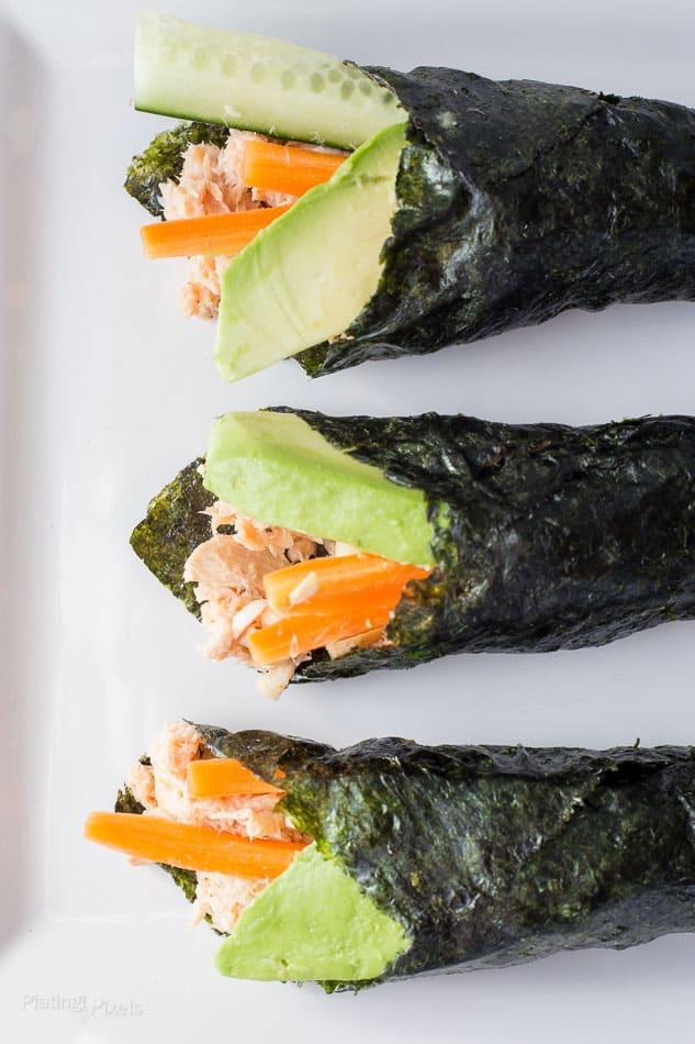 Three paleo tuna salad nori wraps on a white plate.