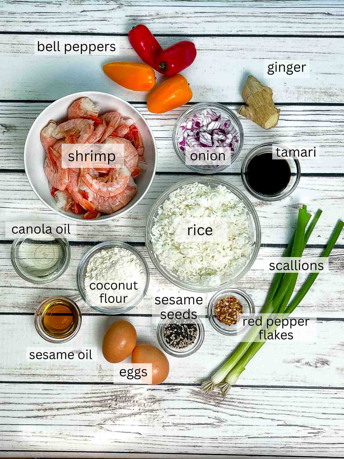 Ingredients in bowls on a white board for making shrimp fried rice cups.