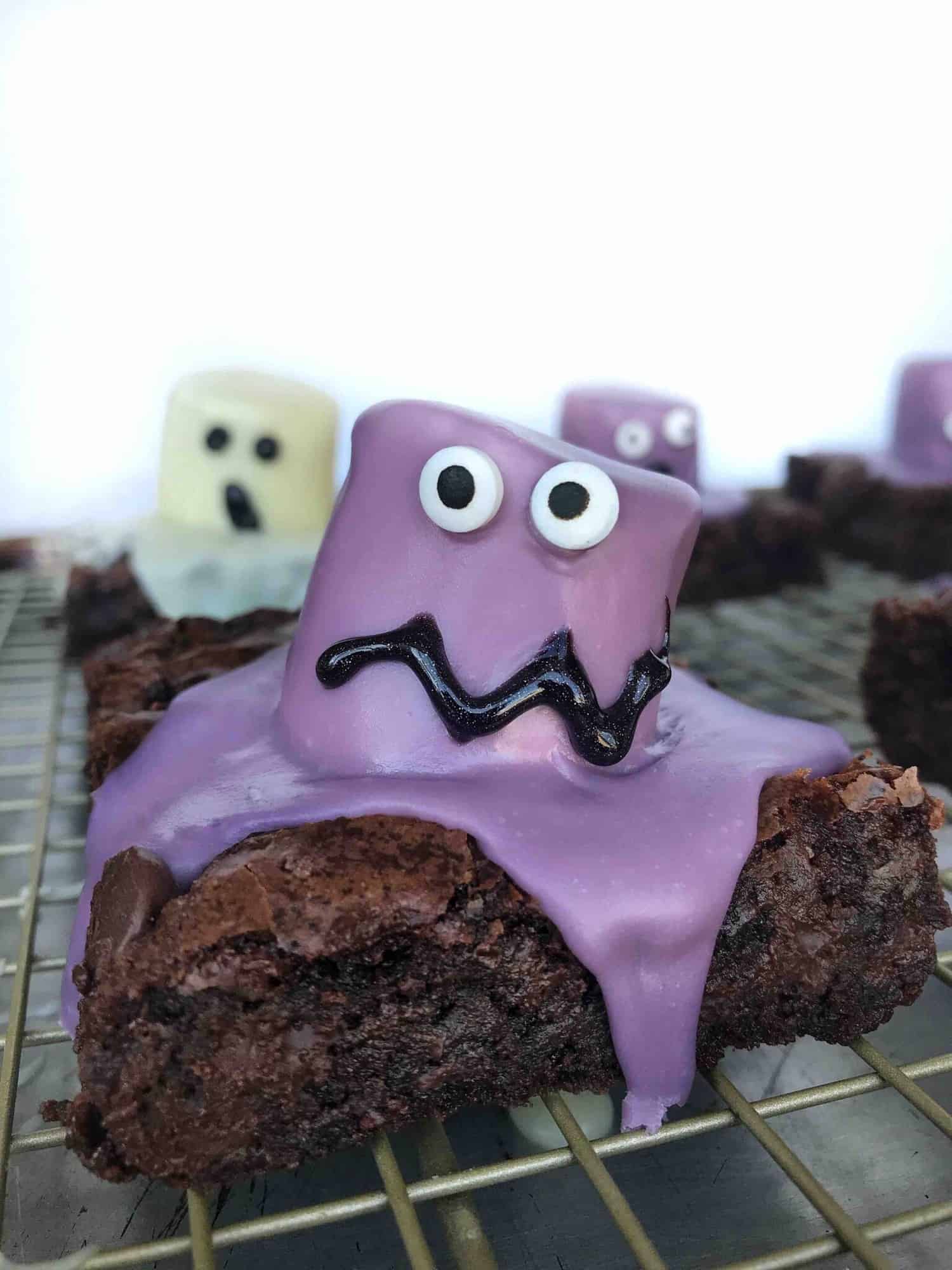 chocolate brownies with decorated marshmallows on top that look like colorful monsters.
