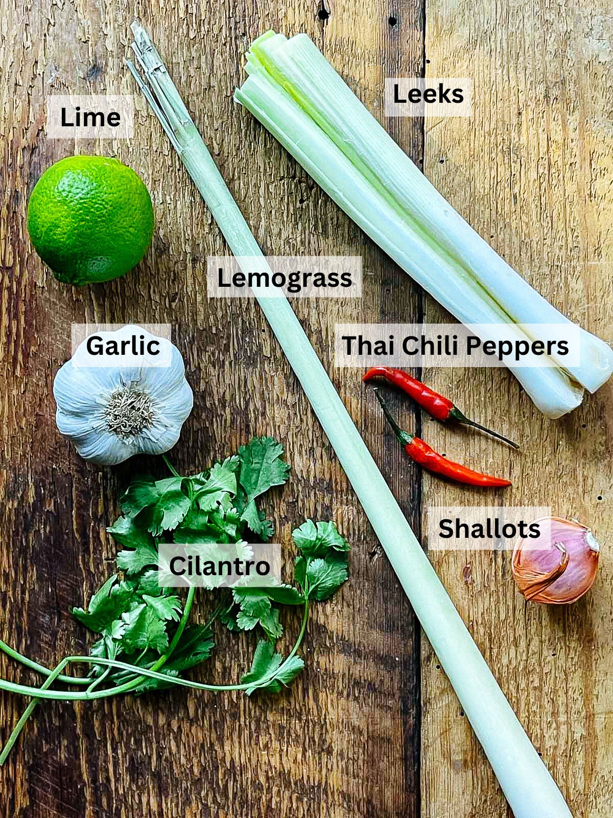 labeled vegetable ingredients for making Thai curry steamed mussels on a wooden board