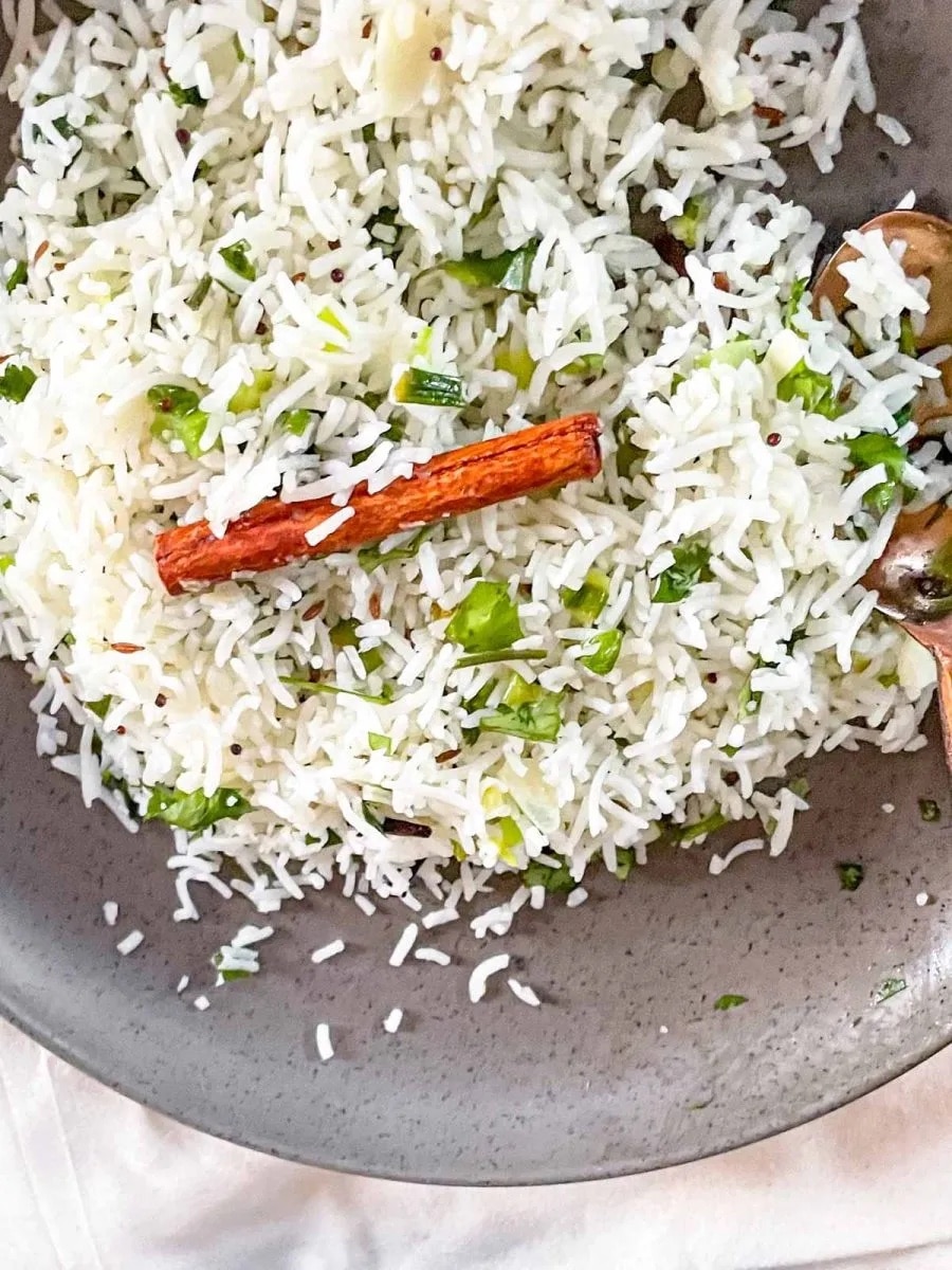 Scalliion Garlic Indian Fried Rice in a gray bowl with a cinnamon stick in the middle.