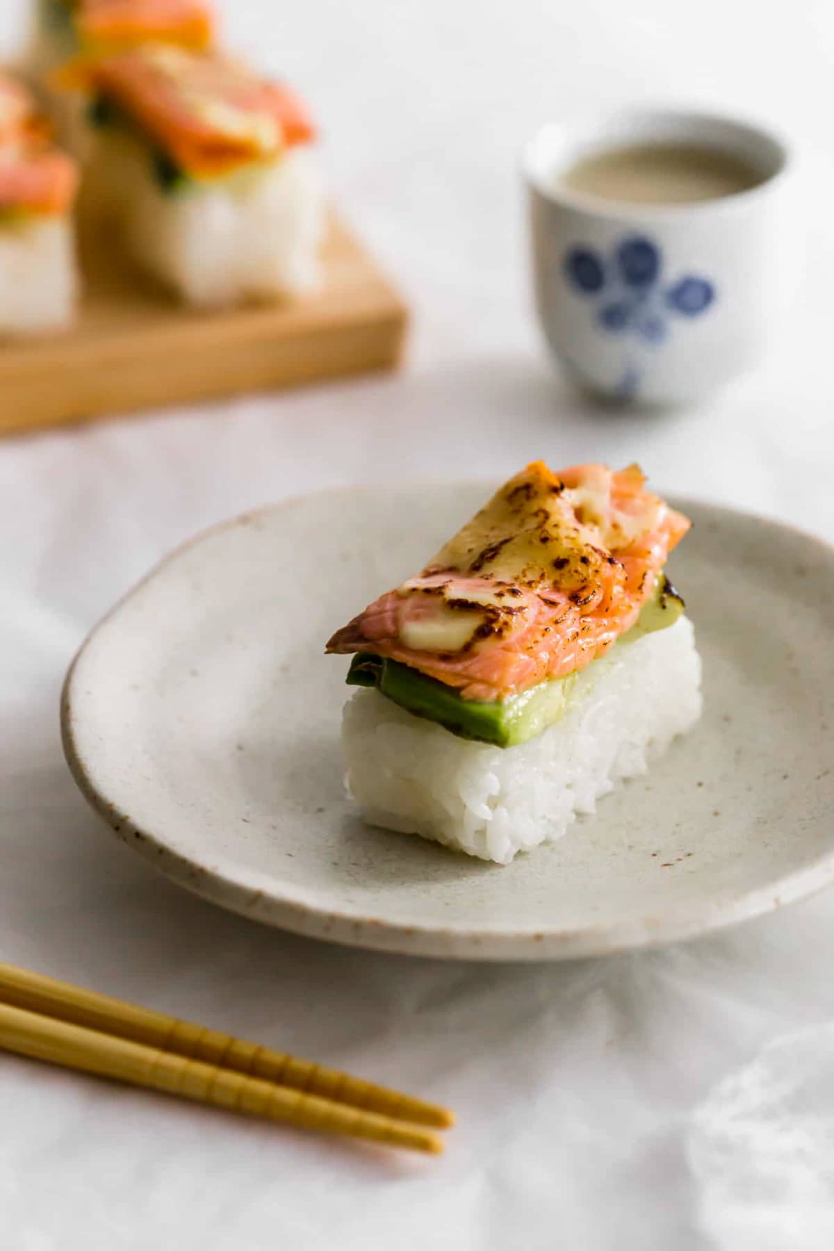 Aburi-Style Smoked Salmon Sushi, a healthy salmon recipe, featuring torched salmon on top of pressed sushi rice and sliced avocado.